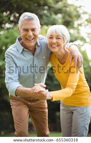 Portrait of happy senior couple dancing in park
