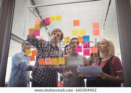 Low angle view of business people planning with adhesive notes in creative office