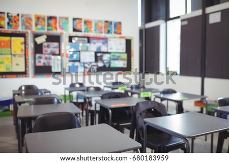 Interior of empty classroom with desks and chairs