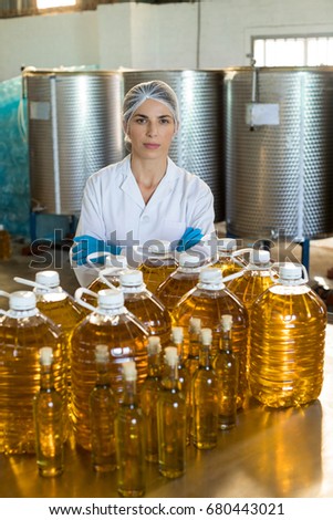 Portrait of confident female technician standing with arms crossed in oil factory