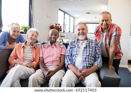 Portrait of multi-ethnic senior people sitting on couch at nursing home