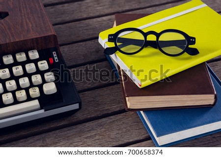 Close-up of vintage typewriter, diary and spectacles on wooden table