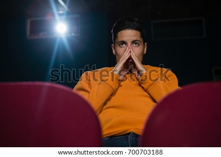 Concentrated man watching movie in theatre