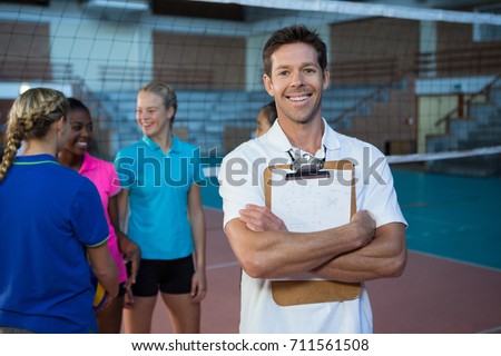 Portrait of smiling male coach standing in the volleyball court