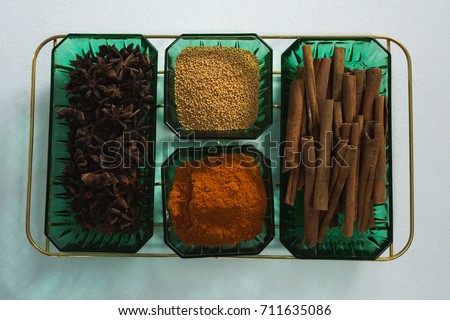 Close-up of anise and cinnamon with spices powder in tray