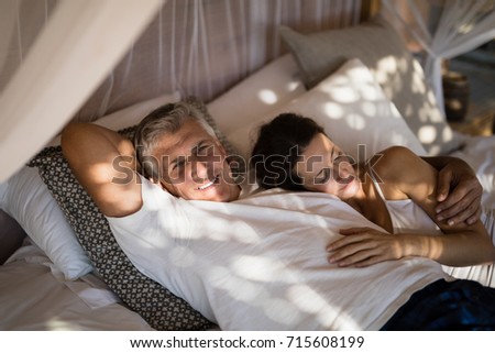 Happy senior couple sleeping on canopy bed