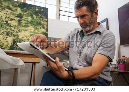 Attentive man painting in drawing book