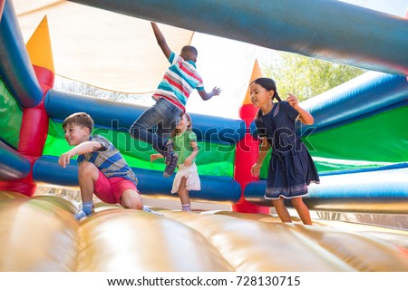Friends jumping on bouncy castle at playground