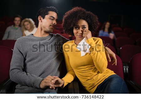 Sad couple watching movie in theatre