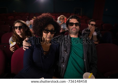 Happy couple watching movie in theatre