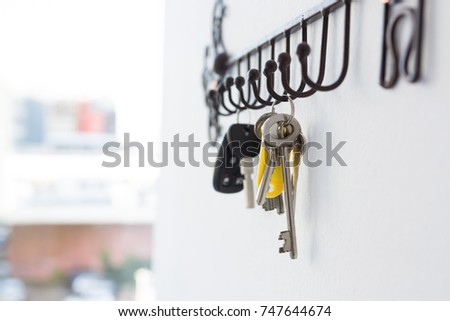 Close-up of various keys hanging on hook against wall