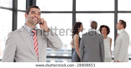 Potrait of a Businessman on the phone in front of business team