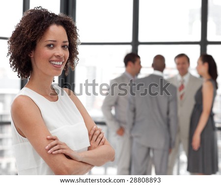 Potrait of a Young Beautiful Business woman smiling in from of Business team