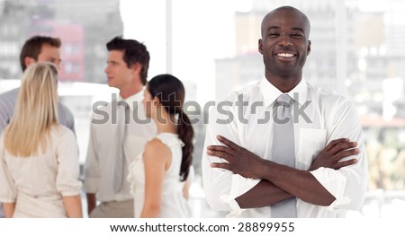 Young African-American Business leader standing inf front of business team smiling