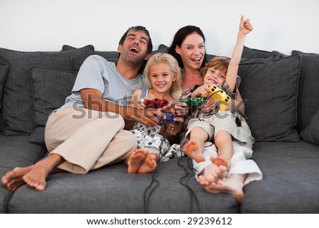 Young Family on Sofa Playing Video games