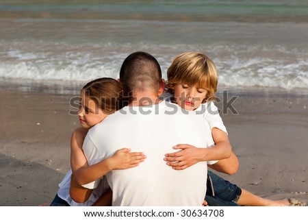 Potrait of Children hugging their father on the beach