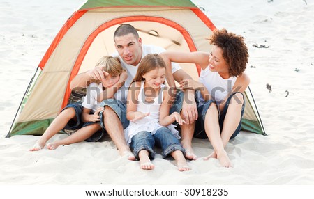 Happy young family camping on beach