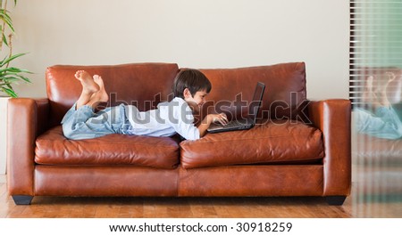 Young kid playing with a laptop on the couch