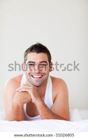 Attractive man in bed smiling to the camera