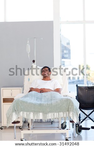 Young patient recovering in bed in hospital with copy-space
