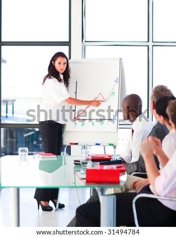 Brunette businesswoman reporting to graphs to her team