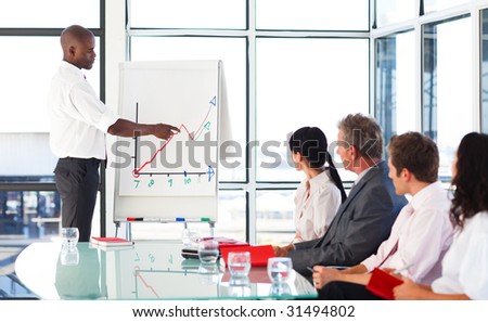Businessman reporting to graphs to his team in a presentation
