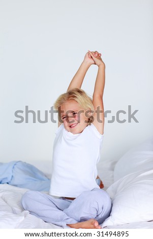 Blonde girl stretching in bed after sleeping