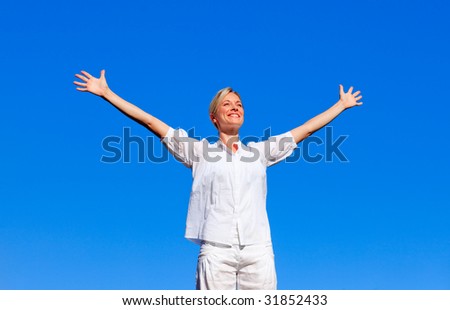 Happy woman feeling free outdoors with open arms