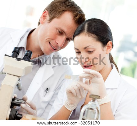 Young scientists looking at a slide under a microscope