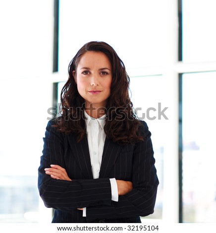 Confident businesswoman with folded arms in office