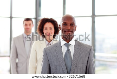 Smiling African-American businessman leading his colleagues in office
