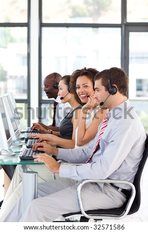 Smiling African-American businesswoman working in a call center with her colleagues