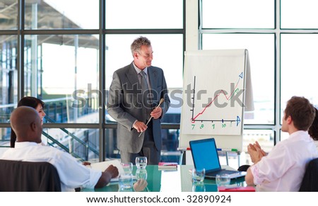 Mature manager in a meeting with his team