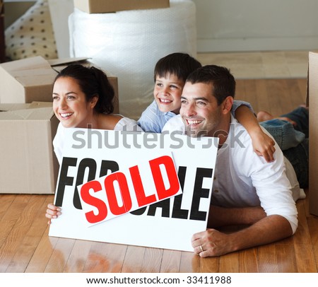 Smiling family on the floor after buying new house