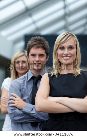 Beautiful blonde businesswoman leading her team with folded arms