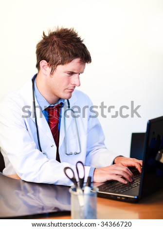 Thoughtful handsome doctor working on a computer in hospital