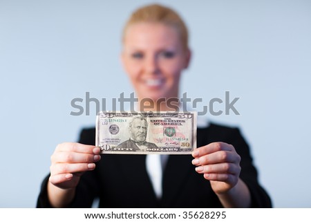 Business woman holding up dollars with camera focus on the dollars
