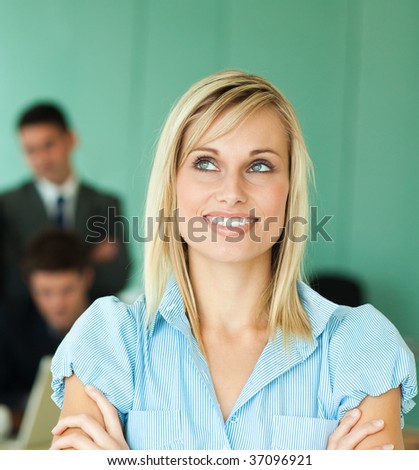 Businesswoman in front of a green office with people working