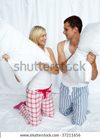 Young couple having a pillow fight in bedroom