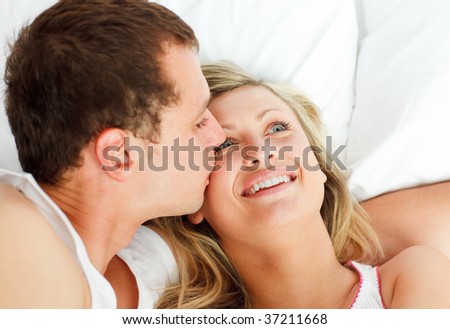 Close-up of boyfriend kissing his girlfriend in bed