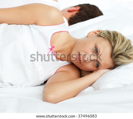 Upset woman in bed sleeping separate of a man