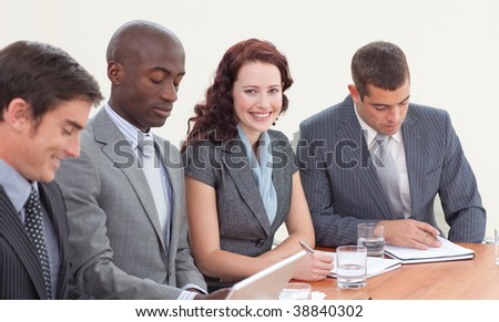 Smiling businesswoman working in a meeting with her colleagues
