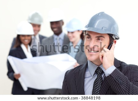 Confident male architect with his team in the background smiling at the camera