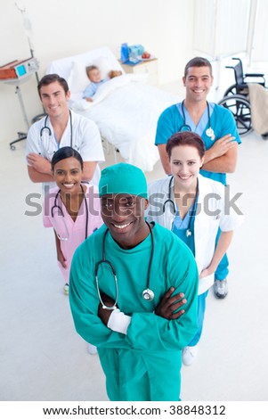 High angle of smiling medical team with a child patient in bed