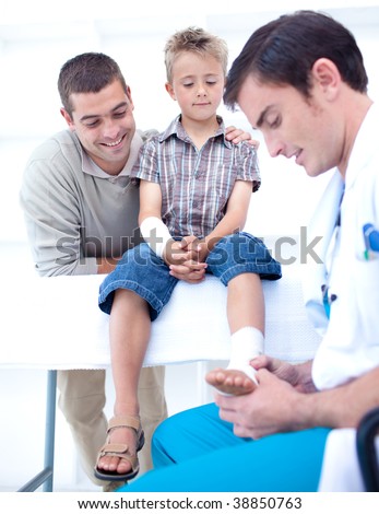 Doctor bandaging a child\'s foot in hospital