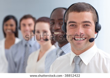 Smiling attractive businessman standing  in a call center in a line
