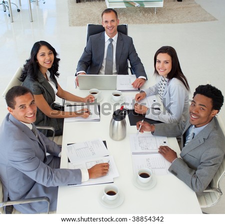 Multi-ethnic business people in a meeting smiling at the camera