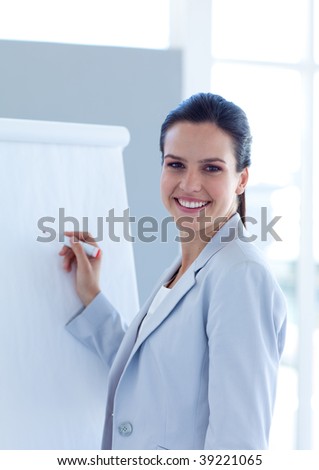 Smiling businesswoman writing in a whiteboard in office