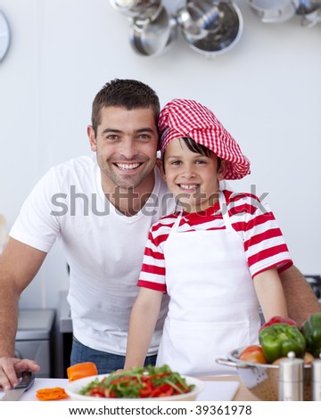 Father and son cooking a salad in kitchen