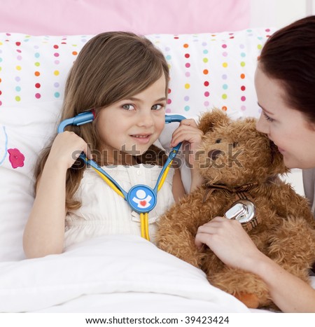 Portrait of a little girl playing with a stethoscope with her mother